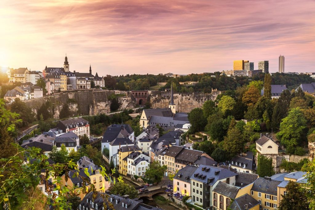 Vue panoramique de Luxembourg‑Ville au coucher du soleil, avec ses quartiers historiques, ses falaises et ses espaces verts illustrant une ville européenne engagée dans la mobilité douce
