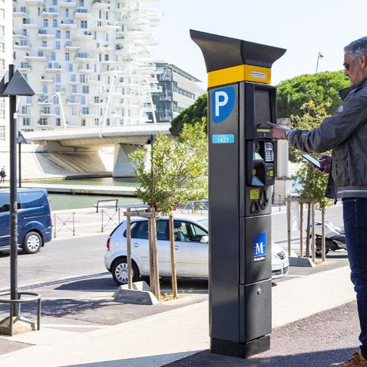 Stationnement payant à Montpellier, un enjeu du quotidien Horodateur de stationnement payant à Montpellier avec voitures en arrière-plan.